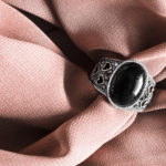 Ring on cloth Vintage black onyx ring on crumpled beige silk as a background schwarzer edelstein onyx obsidian turmalon ring rosa  Element Elemente Heilsteine erde