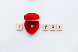 Diamant Ring Hochzeit Ich liebe dich White background with wooden words I LOVE YOU and diamond engagement ring in red gift box. Good as card or background for Valentine's Day of engagement card.